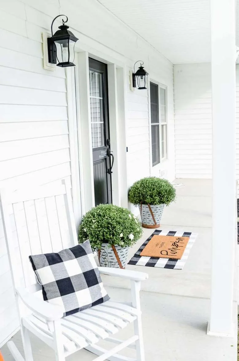 small front porch decorating ideas - With black buffalo check pillows (you can order them to DIY), a pumpkin mat, vintage buckets, white mums, and classic white rockers you will have your own Farmhouse Fall Porch! #frontporchideas #modernfarmhousefalldecor #smallfrontporchdecoratingideas