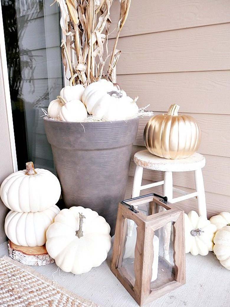 small front porch decorating ideas - dark rich neutrals mixed with metallics and a little bit of orangy rust color to decorate for fall; white pumpkins, and bronze paint drip pumpkins with Vibrant mums and cornstalks 'planted' in large dark planters #frontporchideas #outdoorfalldecoratingideas #smallfrontporchdecoratingideas