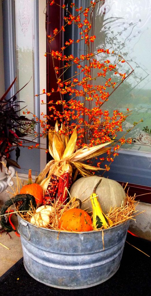small front porch decorating ideas - easy farmhouse washtub centerpiece with colorful fall gords, pumpkins, corn, and fall bushes #frontporchideas #outdoorfalldecoratingideas #smallfrontporchdecoratingideas